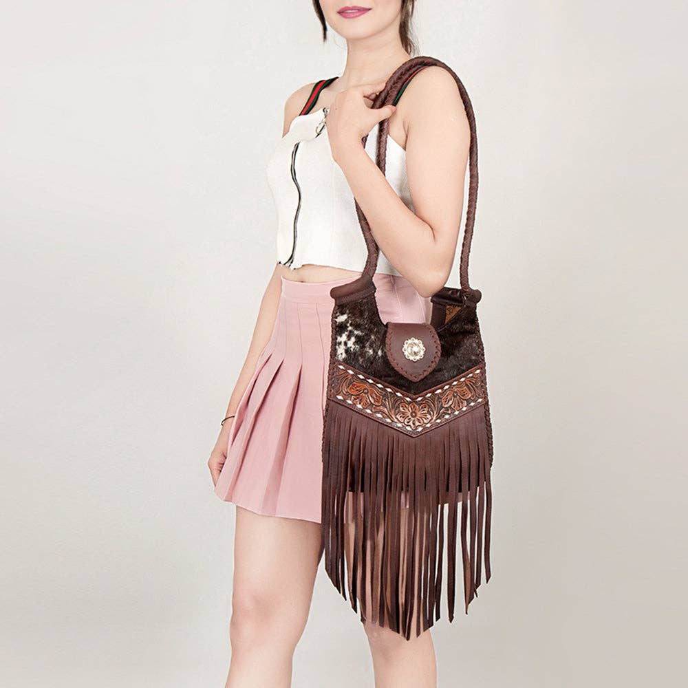 Woman holding a brown Western Leather Women Bag handbag against a plain background
