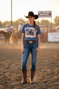Heather Gray t-shirt on a lady with cowboy hat and boots at a horse arena.
