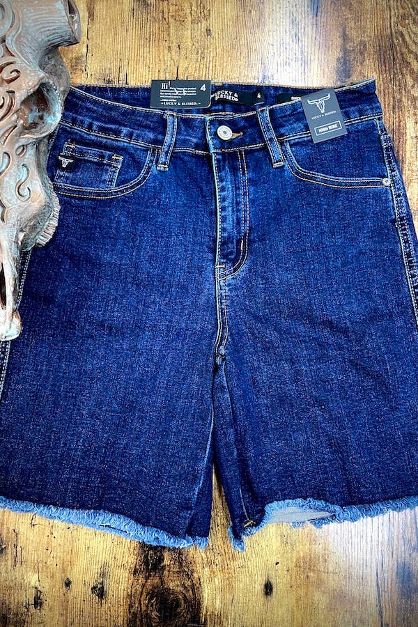 Dark wash denim shorts folded neatly on a white background