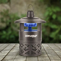Dynatrap mosquito trap on a wooden surface with a blurred green background