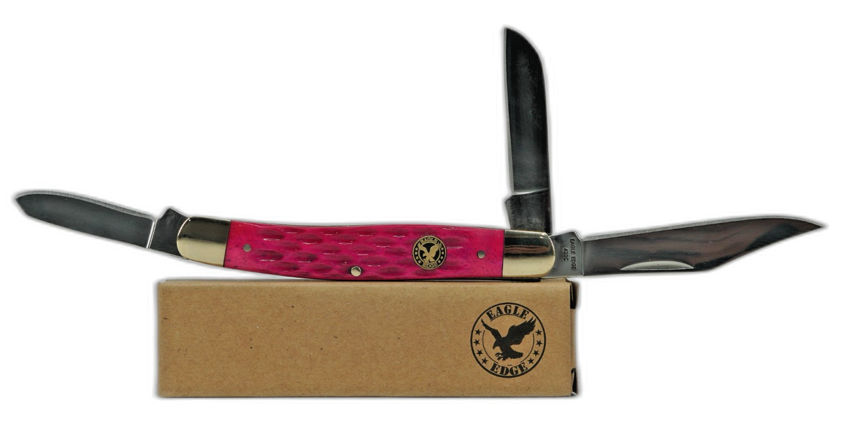 Folding knife with pink handle and black blade on a cardboard box, brand logo visible.