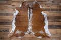 Real Red and white cowhide rug on a rustic wood floor