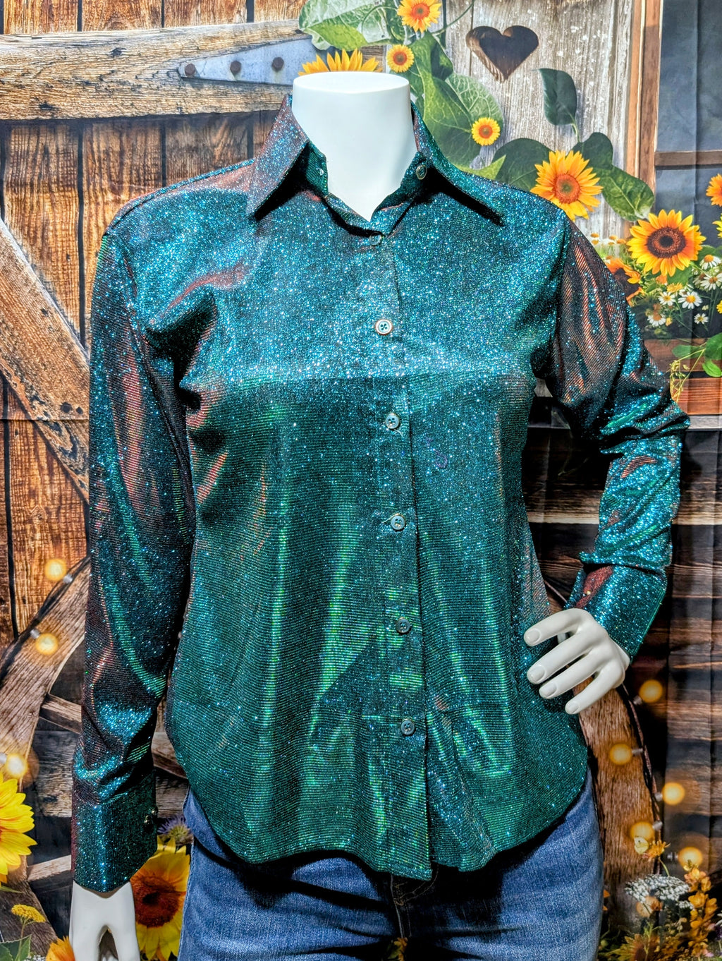 Green sparkly Western show shirt with pointed collar displayed on mannequin against neutral background.