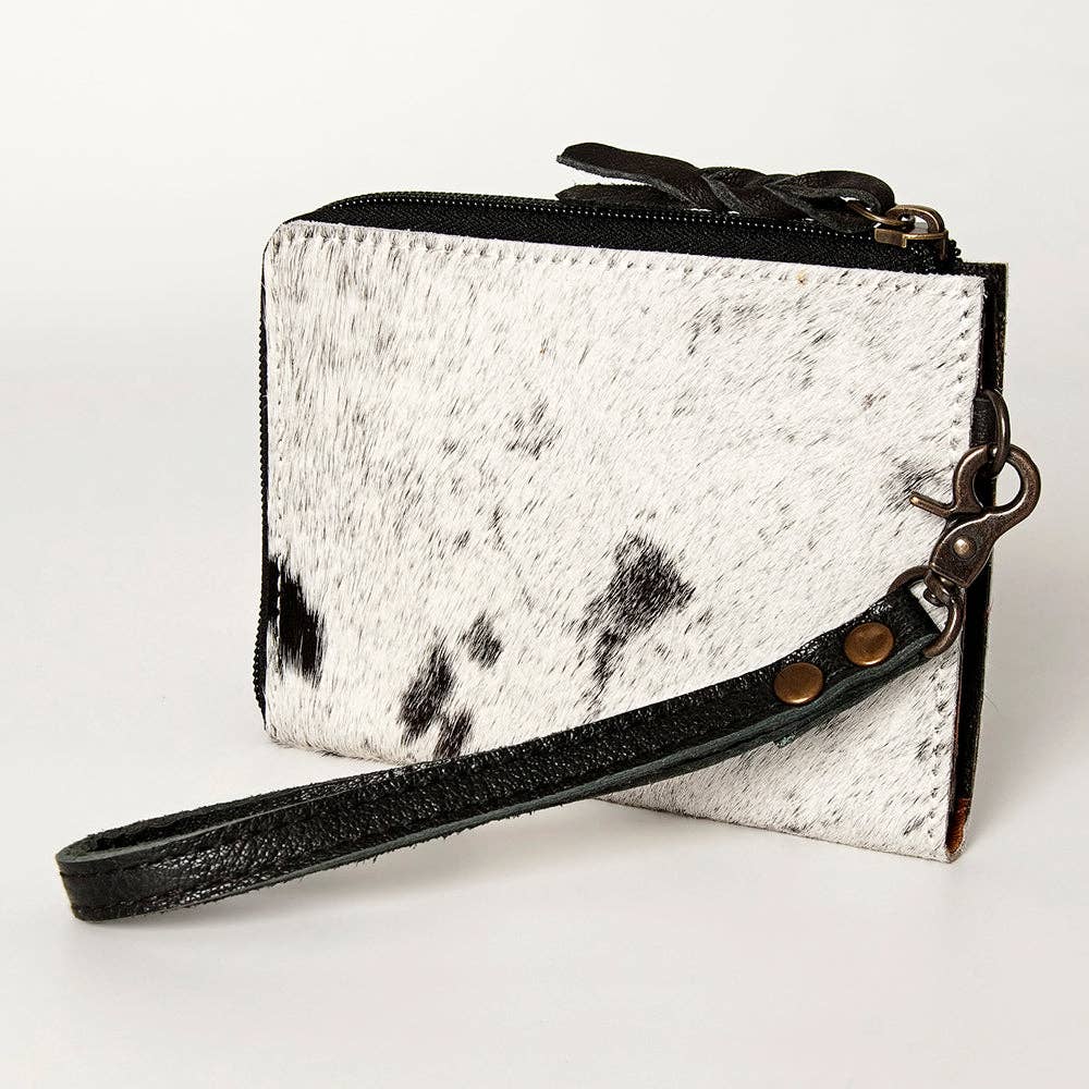 White cowhide leather wallet with black spots and a wrist strap on a white background