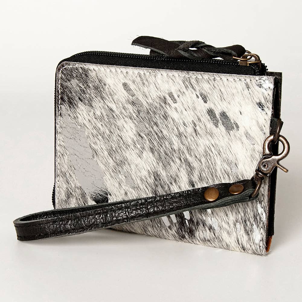 Black and white cowhide leather wallet with wrist strap on a white background