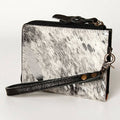 Black and white cowhide leather wallet with wrist strap on a white background