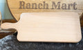 Handcrafted cedar wood cutting board with handle featuring engraved Ranch Mart branding