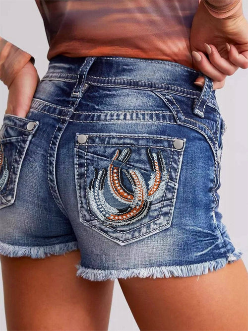 Lady wearing denim shorts back view with embroidered horseshoes on the pockets