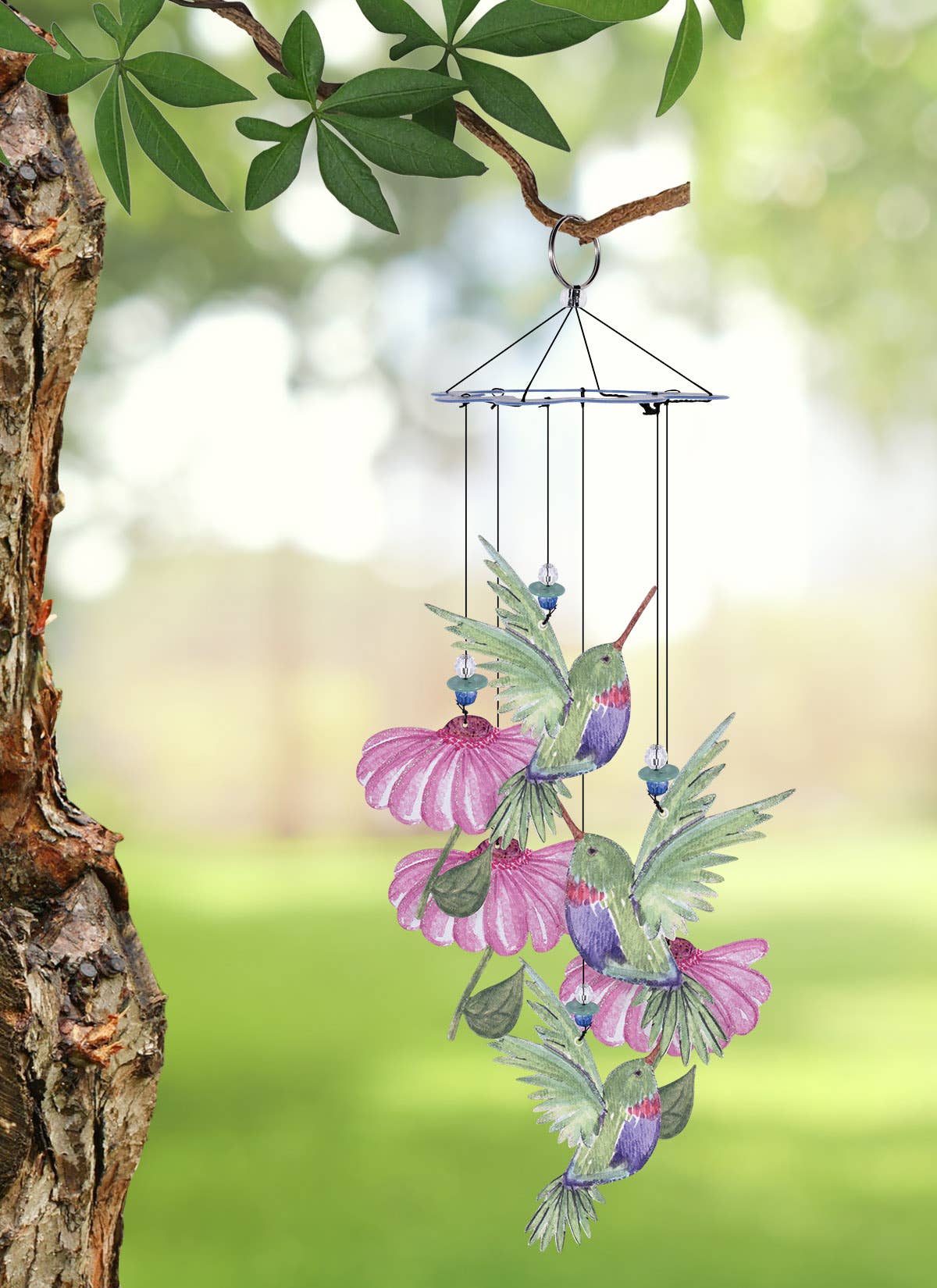 Decorative wind chime shaped like a hummingbird and flowers hanging from a tree branch.