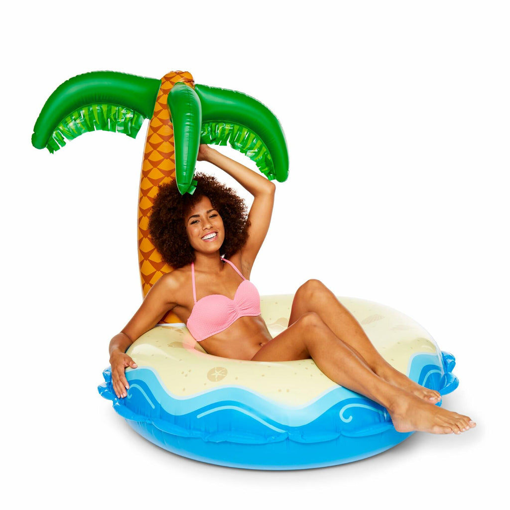 Woman sitting on a palm tree-shaped inflatable pool float.