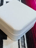 Closed ivory jewelry case next to travel accessories