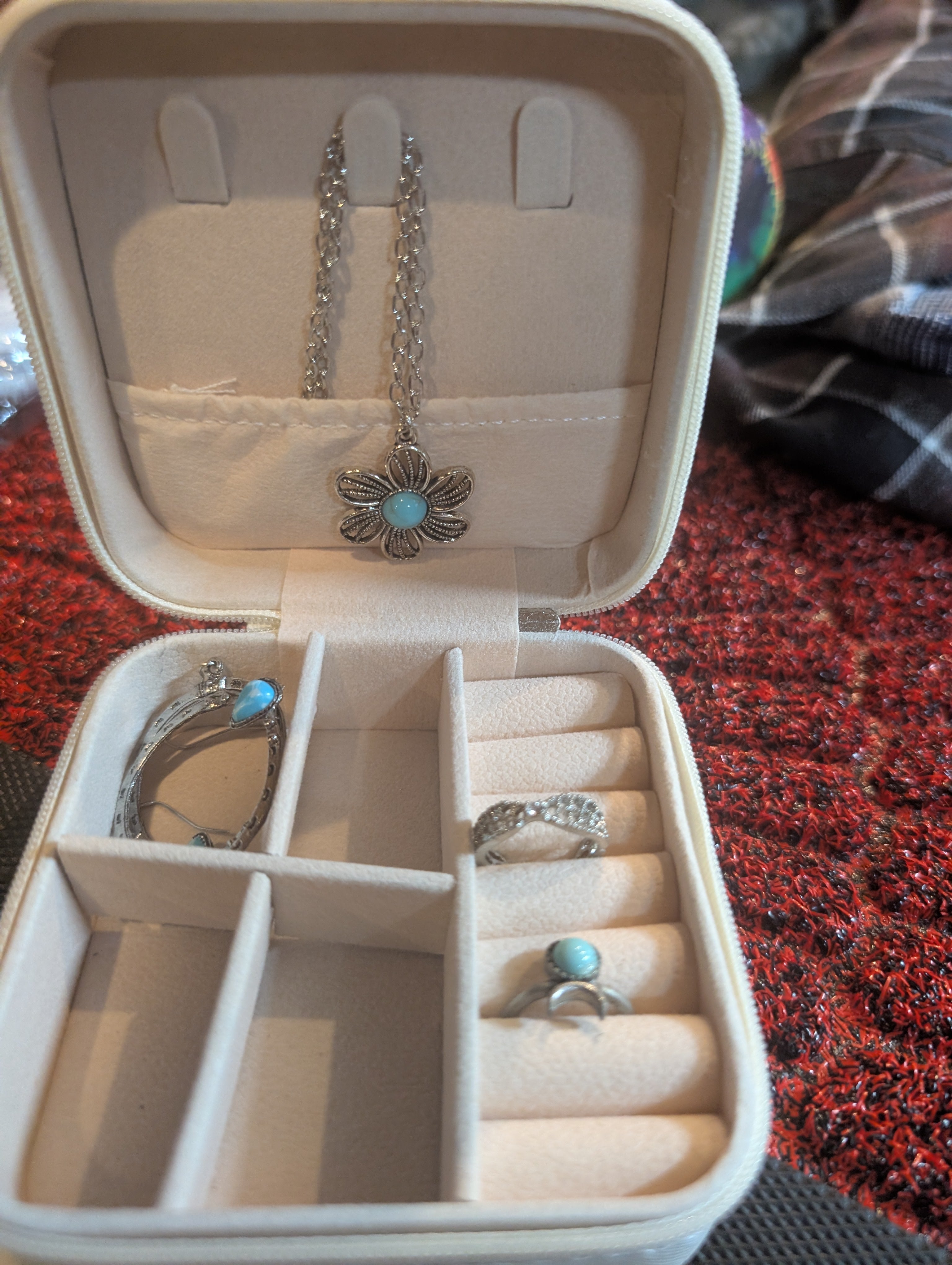 Jewelry box with a necklace and rings on a textured surface