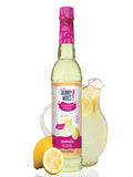Jordan’s Skinny Mixes Sugar Free Lemonade Syrup bottle on a kitchen counter next to a glass of iced lemonade.