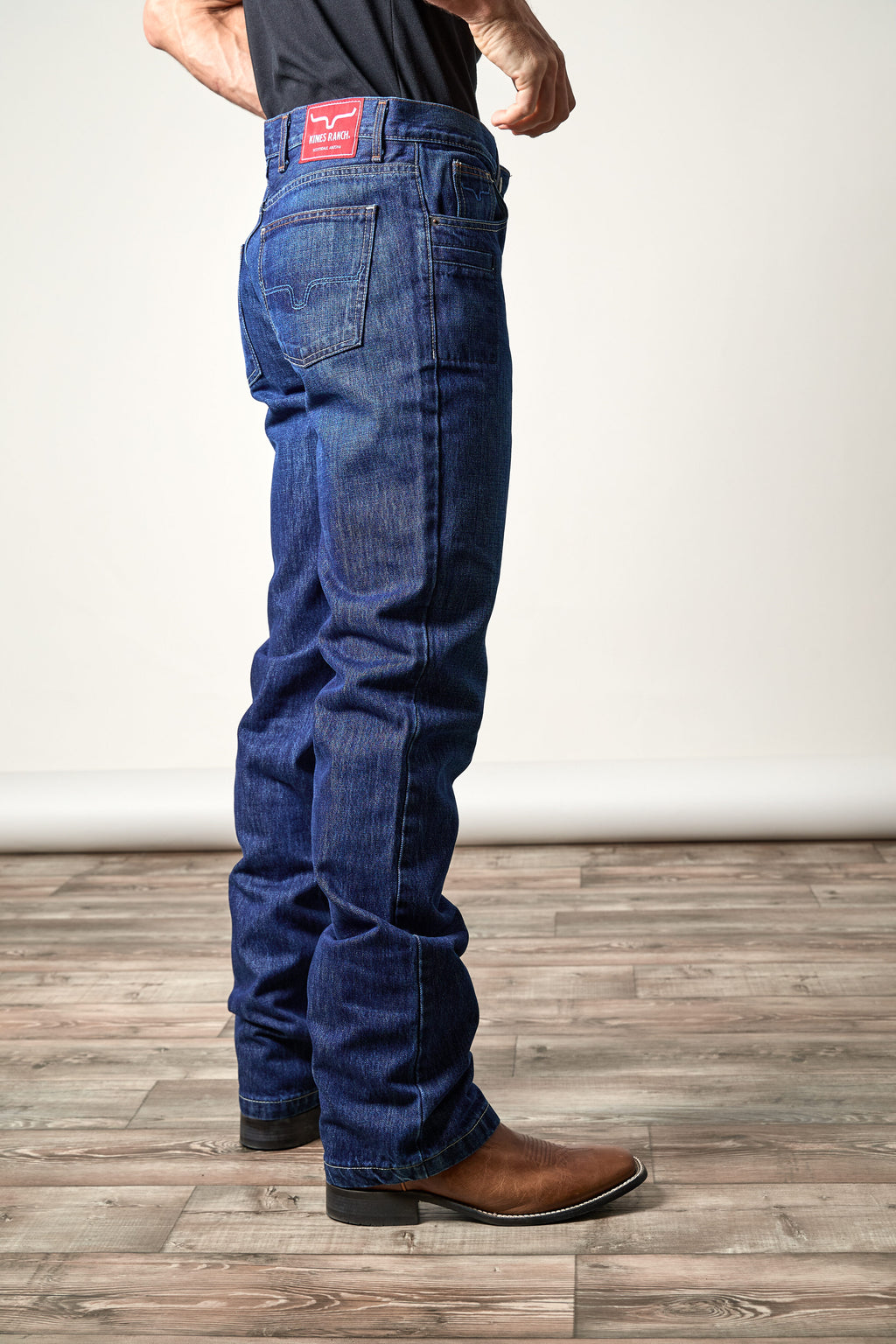 Back view of Kimes Ranch Dillon men's mid-rise relaxed straight leg jeans paired with brown boots.