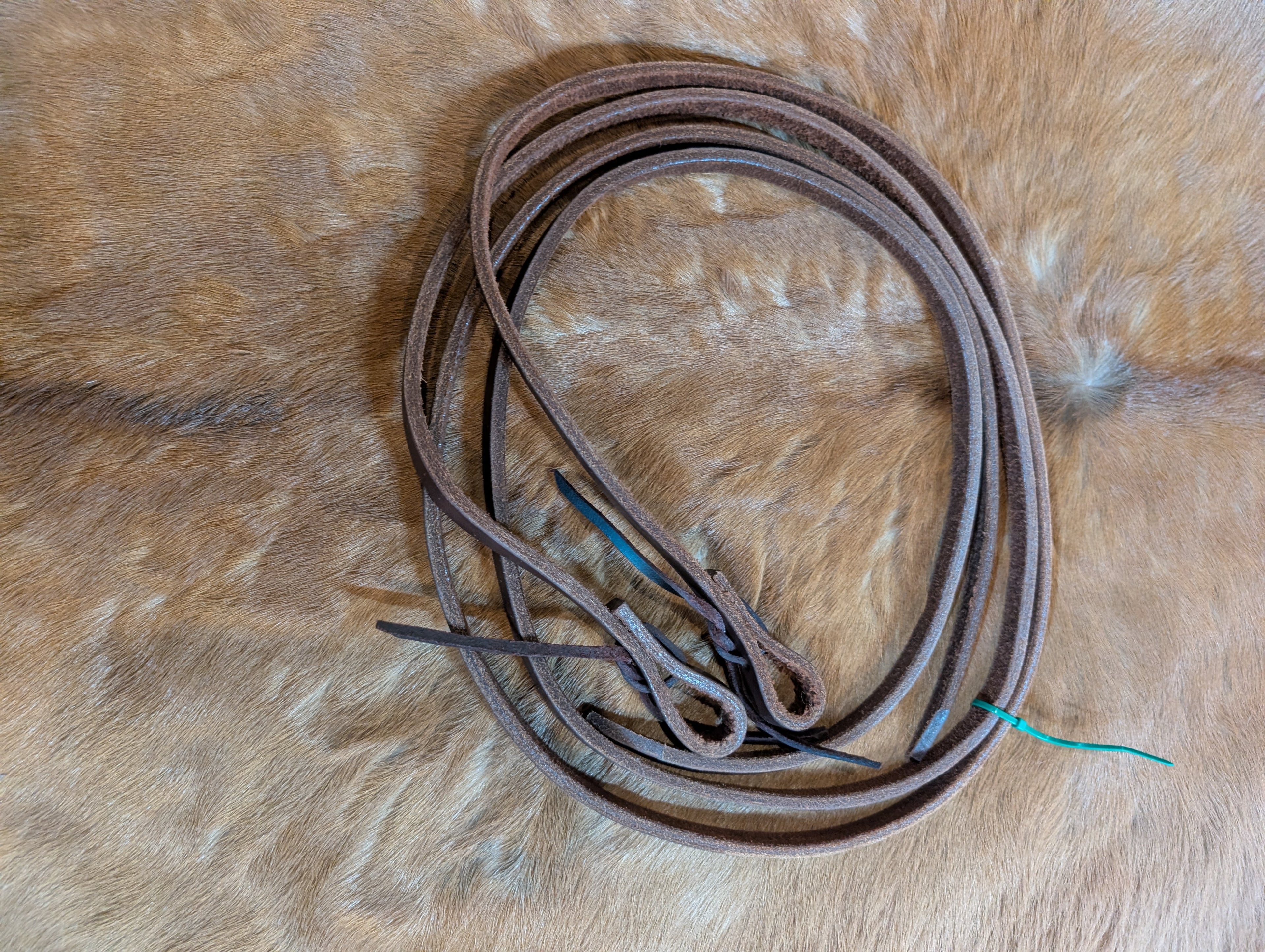 A pair of dark oiled leather pony split reins.