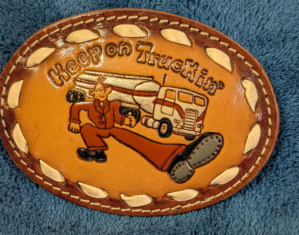 Leather “Keep on Truckin’” Belt Buckle on blue fabric
