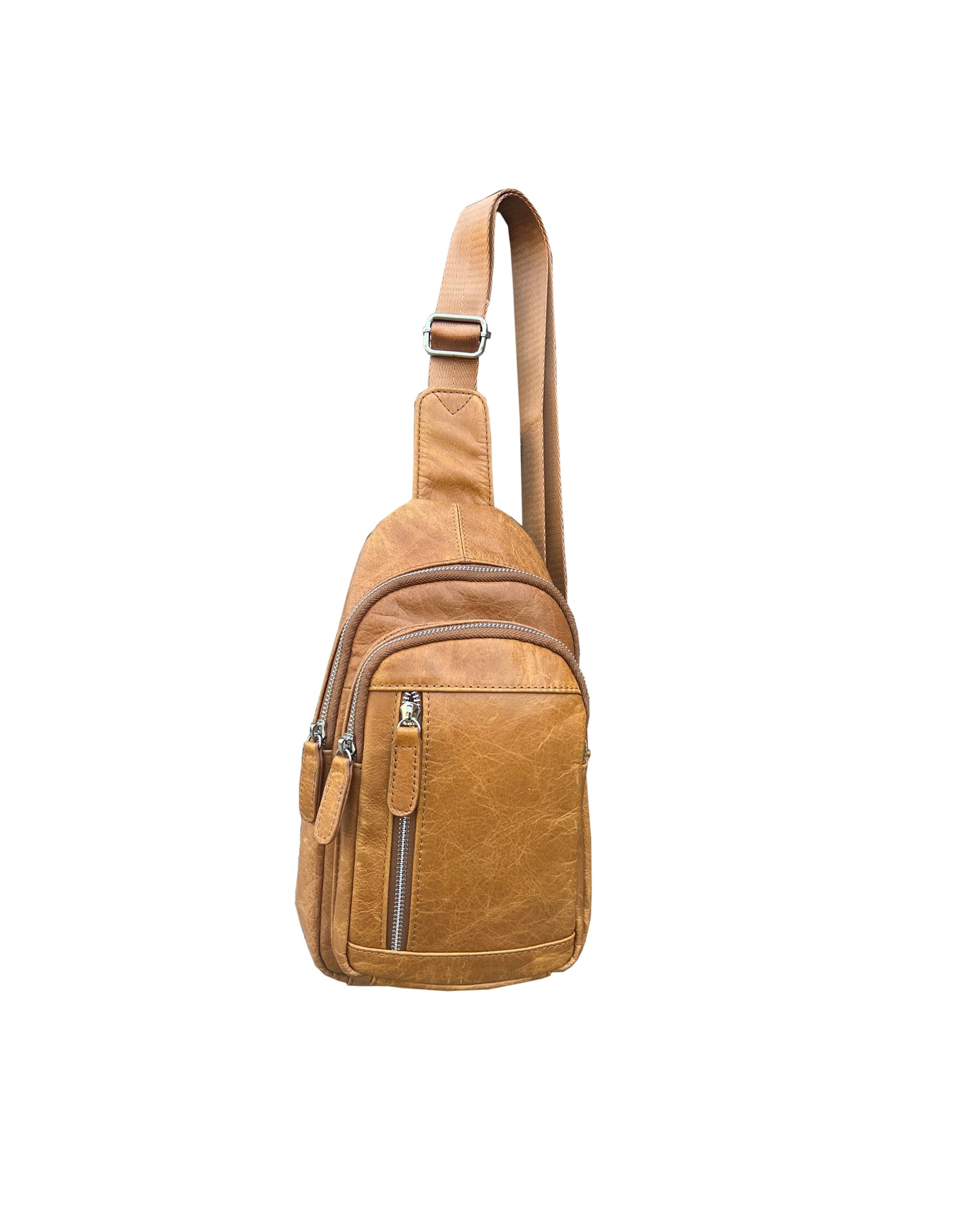 Tan cowhide leather sling bag on a white background