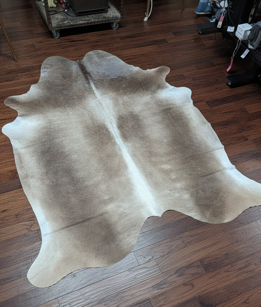 Brown cowhide rug on a wood floor