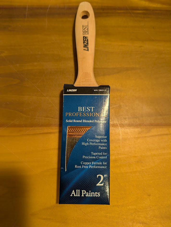Paint brush with packaging labeled 'Best Profession' on a wooden surface