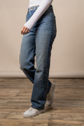 Model wearing Kimes Ranch Mia high-rise relaxed straight leg boyfriend jeans with white sneakers.