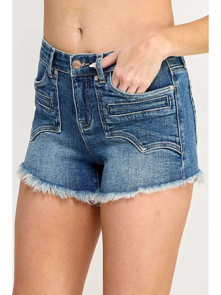 Plus size mid-rise denim shorts with tummy control and Western embroidered pockets, styled with cowboy boots.