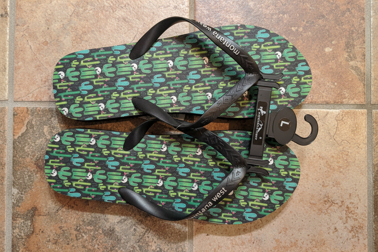 Pair of green and black flip-flops with a pattern on a tiled floor.