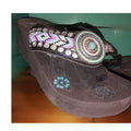 Close-up of turquoise gem beaded concho and floral logo on wedge sandal sole, no returns