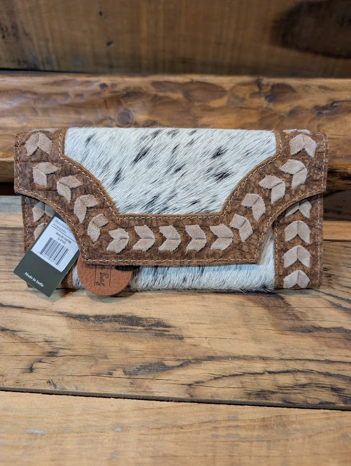 Cowhide wallet with decorative stitching on a wooden surface