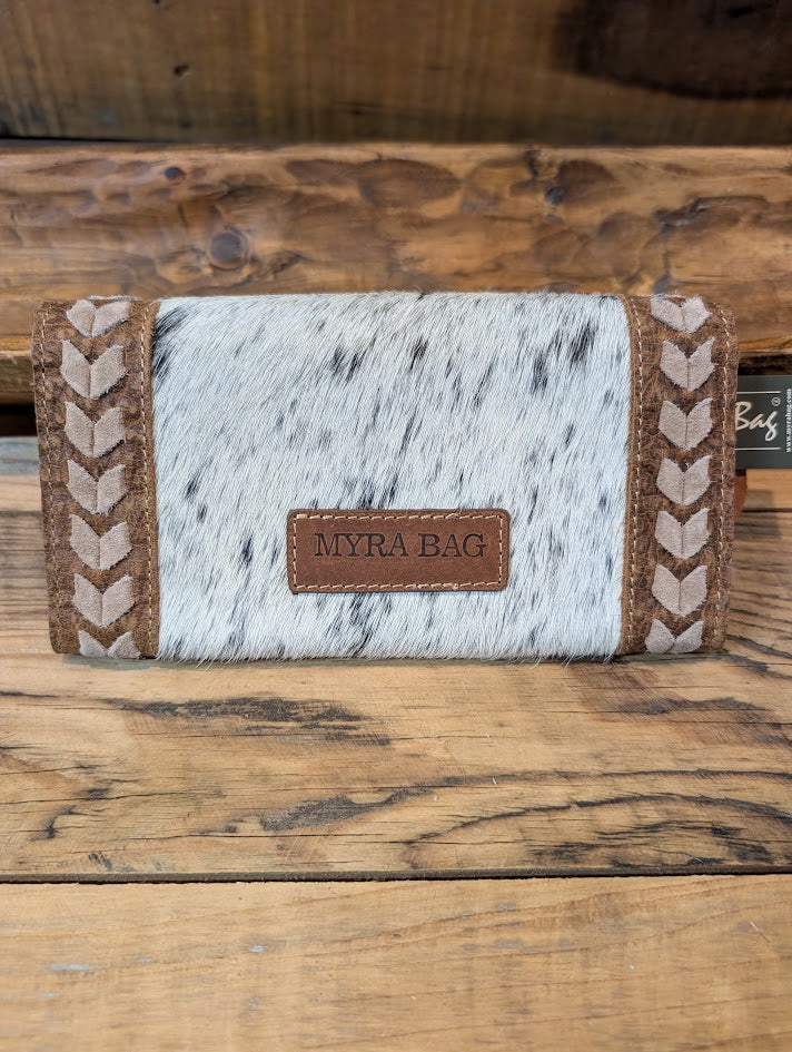 Handmade wallet with cowhide leather and braided edges on a wooden surface, featuring the brand 'MYRA BAG'.