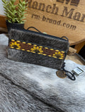 A multicolored wallet with a mix of solid colors and patterned sections, placed on a textured surface.