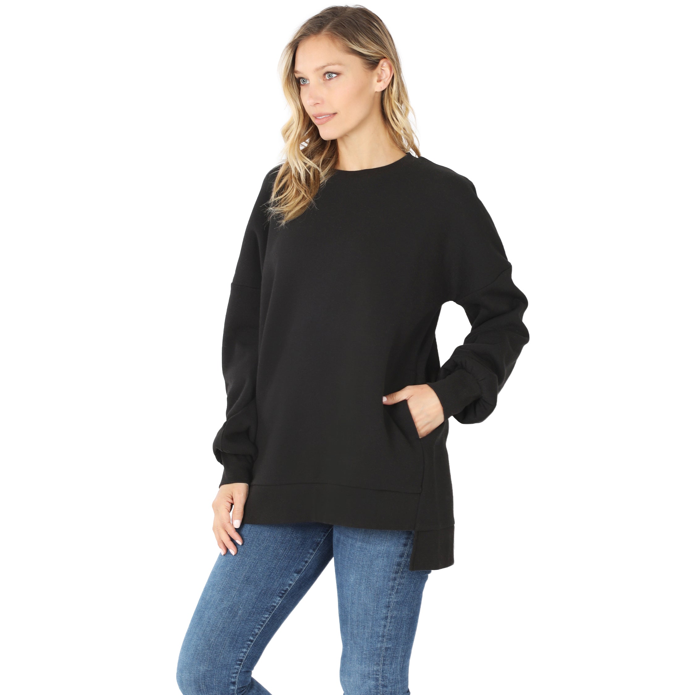 Woman wearing a black sweater and blue jeans on a white background