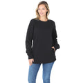 Woman wearing a black long sleeve round neck sweatshirt and blue jeans