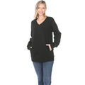 Woman wearing a black sweater and blue jeans on a white background