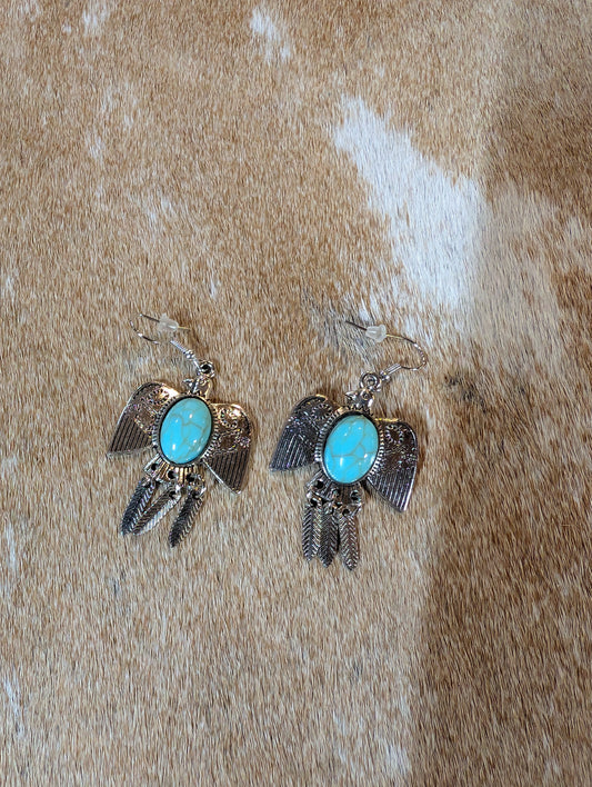 Spirit of the Southwest thunderbird earrings featuring turquoise stones and antique silver finish, displayed on rustic background