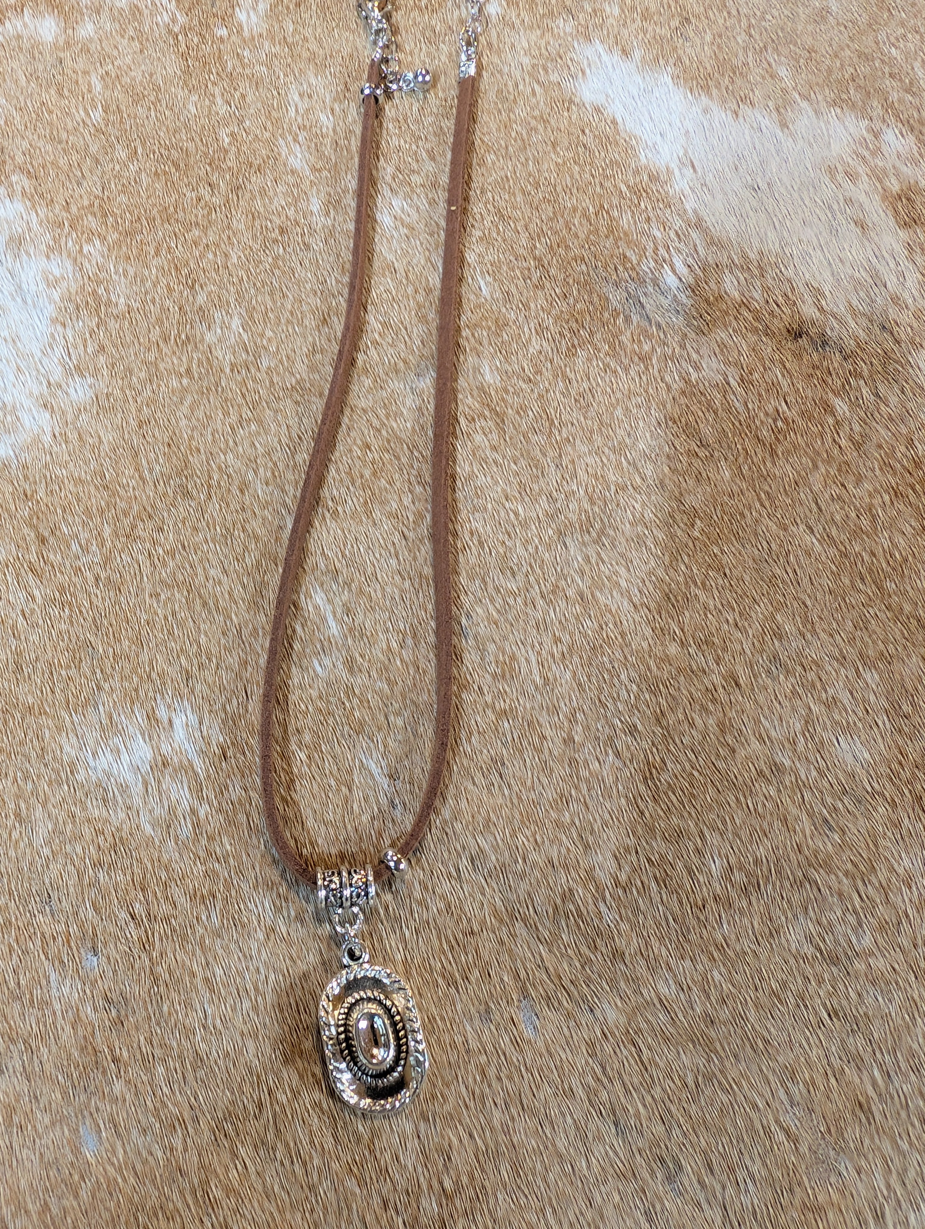 Necklace with a decorative pendant on a textured beige surface