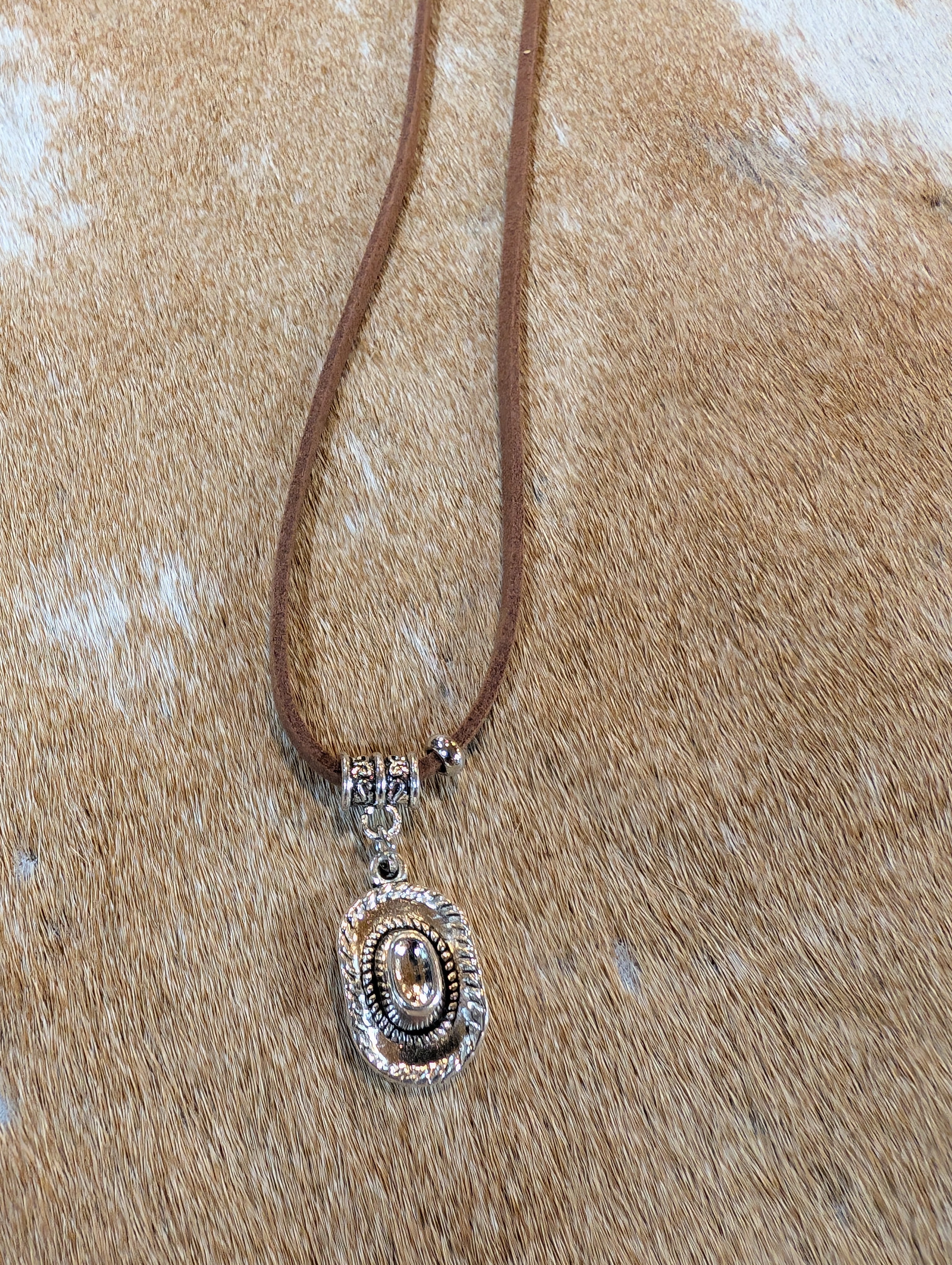 Necklace with a pendant on a textured beige surface