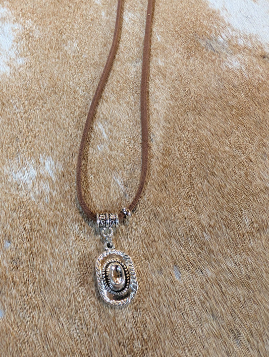 Necklace with a pendant on a textured beige surface