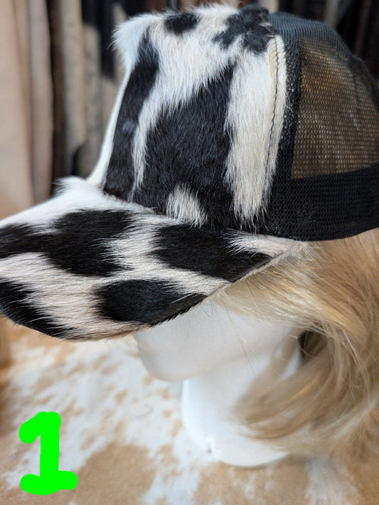 Black and white cowhide patterned cap on a mannequin head with a blurred background