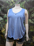 Mannequin wearing a blue tank top and black shorts against a leaf-patterned background