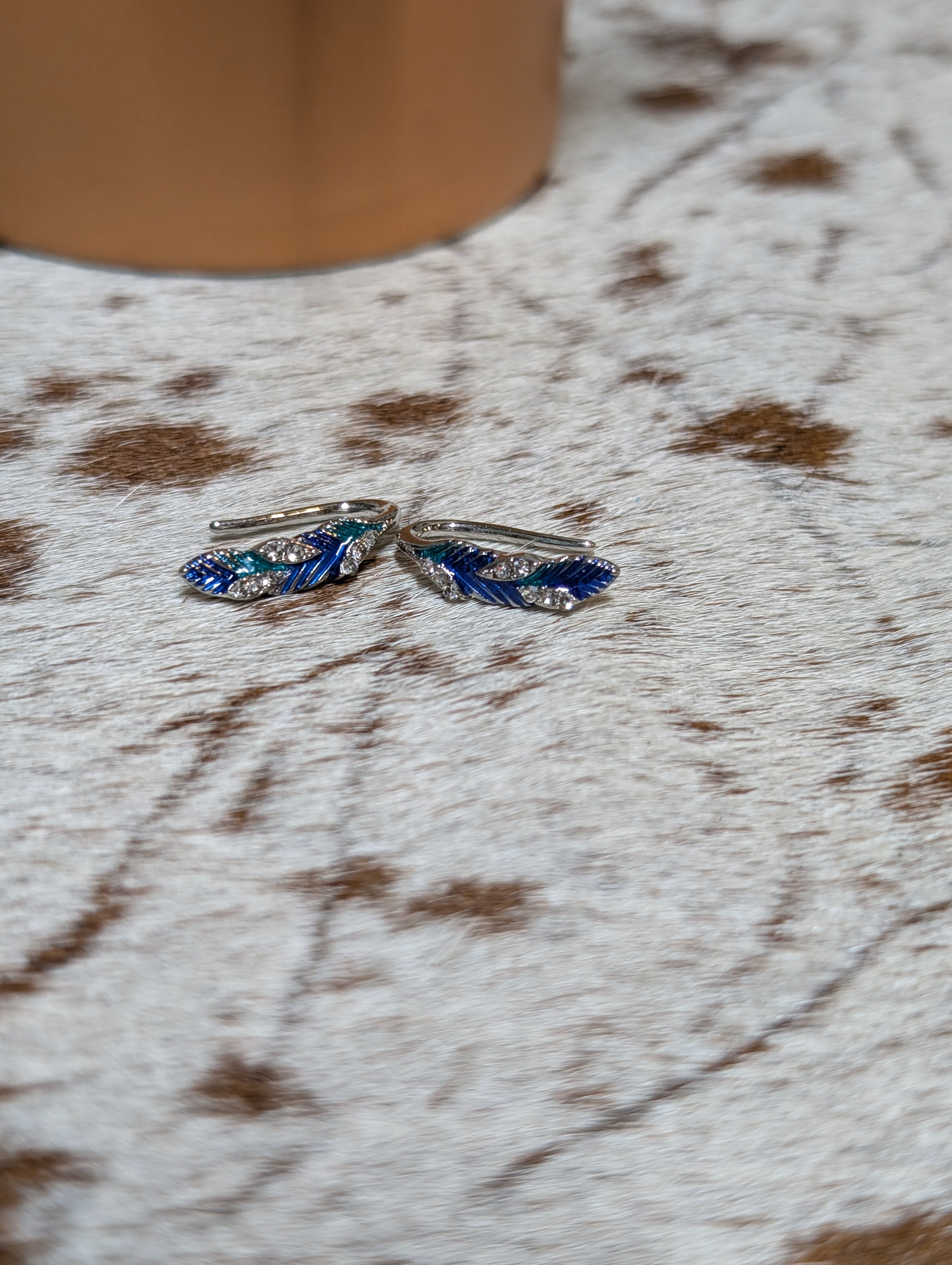 Blue feather fashion earrings with sparkling crystal accents, western-inspired drop jewelry.