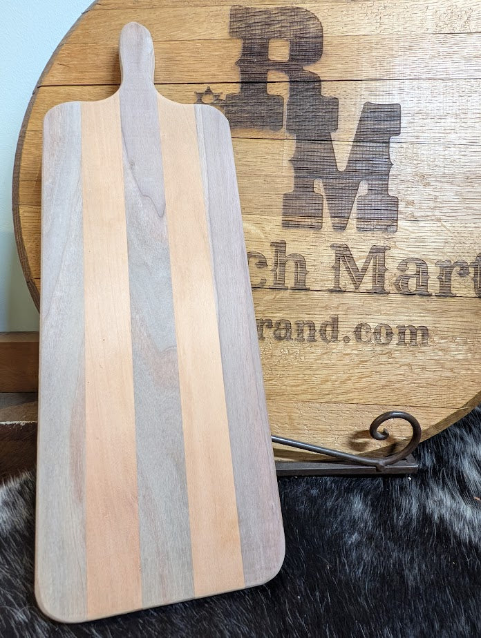 Wooden cutting board with striped design on a wooden stand with branding text.