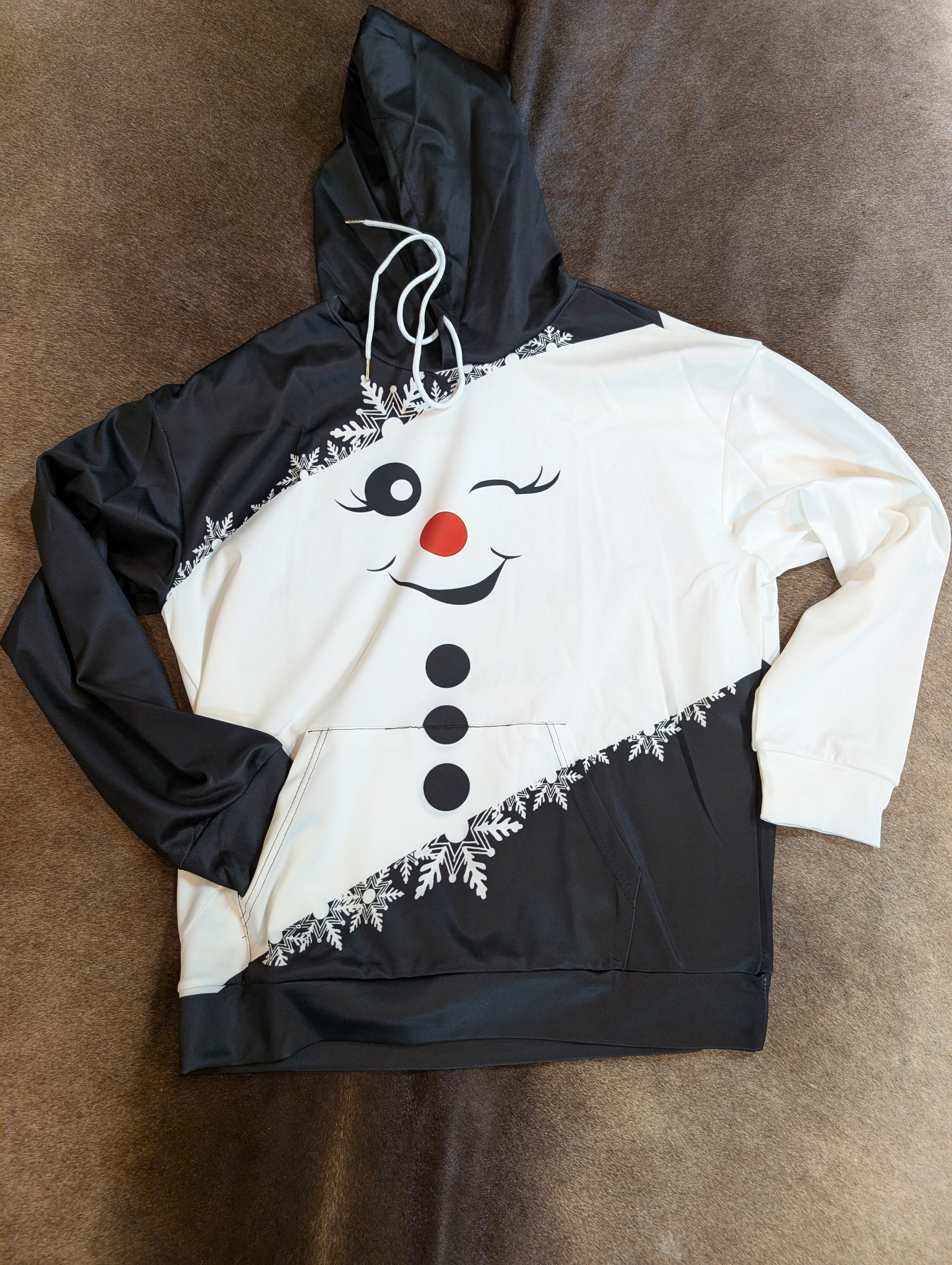 Hoodie with a snowman design on a brown surface