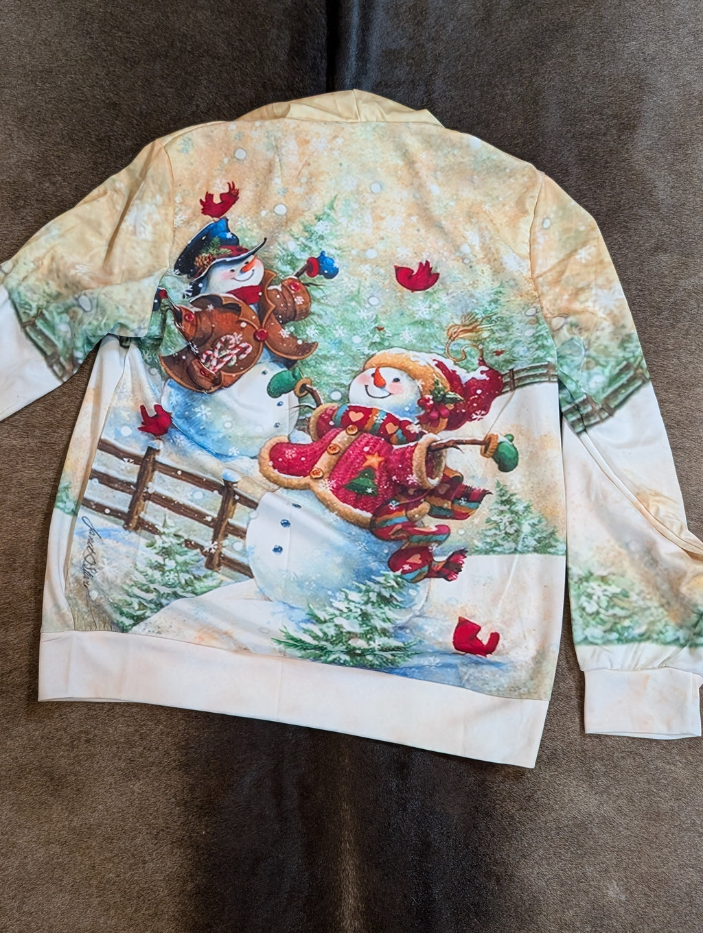 Christmas-themed sweatshirt with snowmen and cookies on a brown background