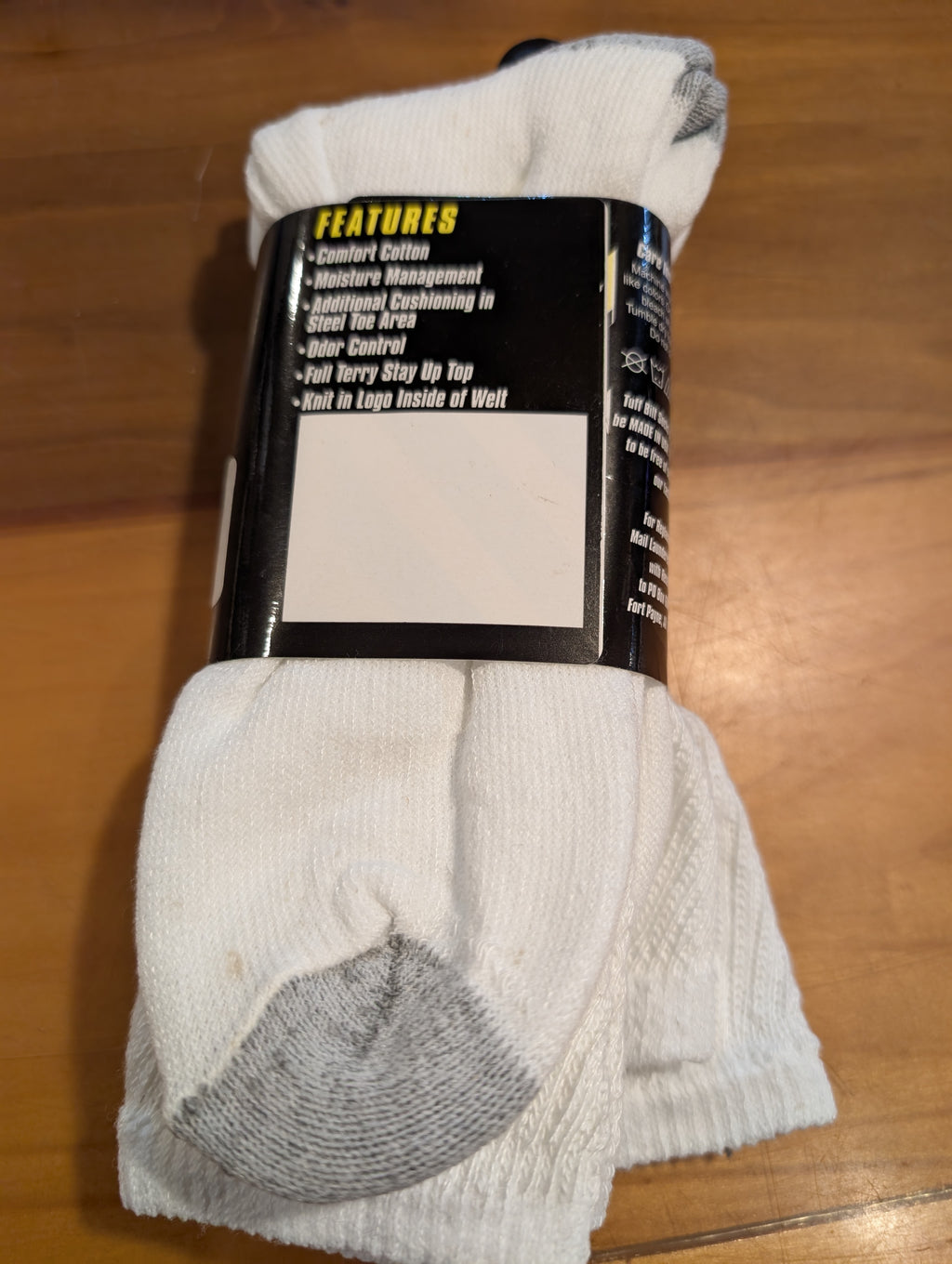 White socks with a black label on a wooden surface