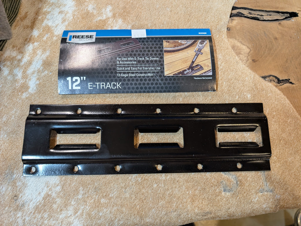Black E-Track component with Reese packaging on a cardboard surface