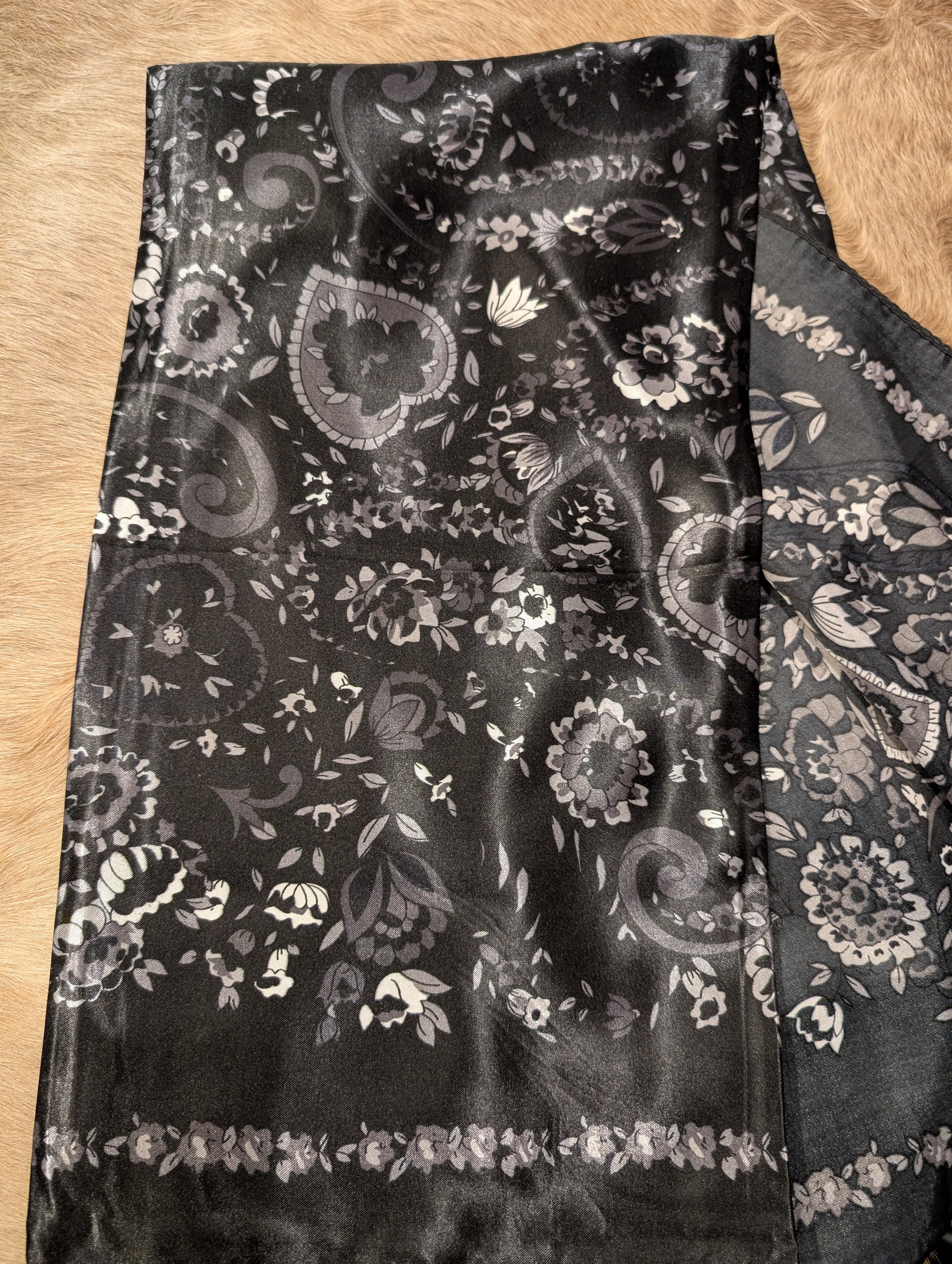 Black floral patterned fabric on a wooden surface