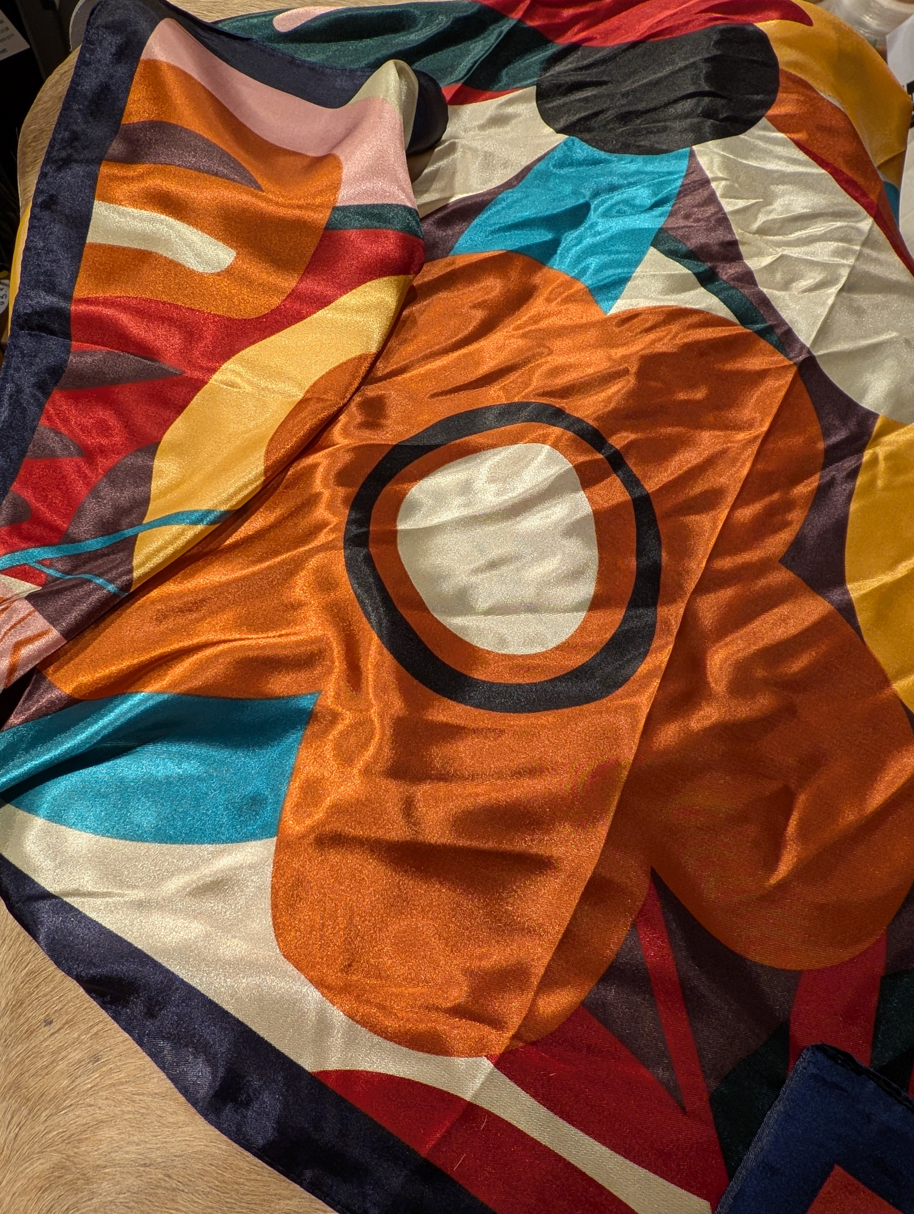 Colorful abstract patterned fabric with geometric shapes on a wooden surface