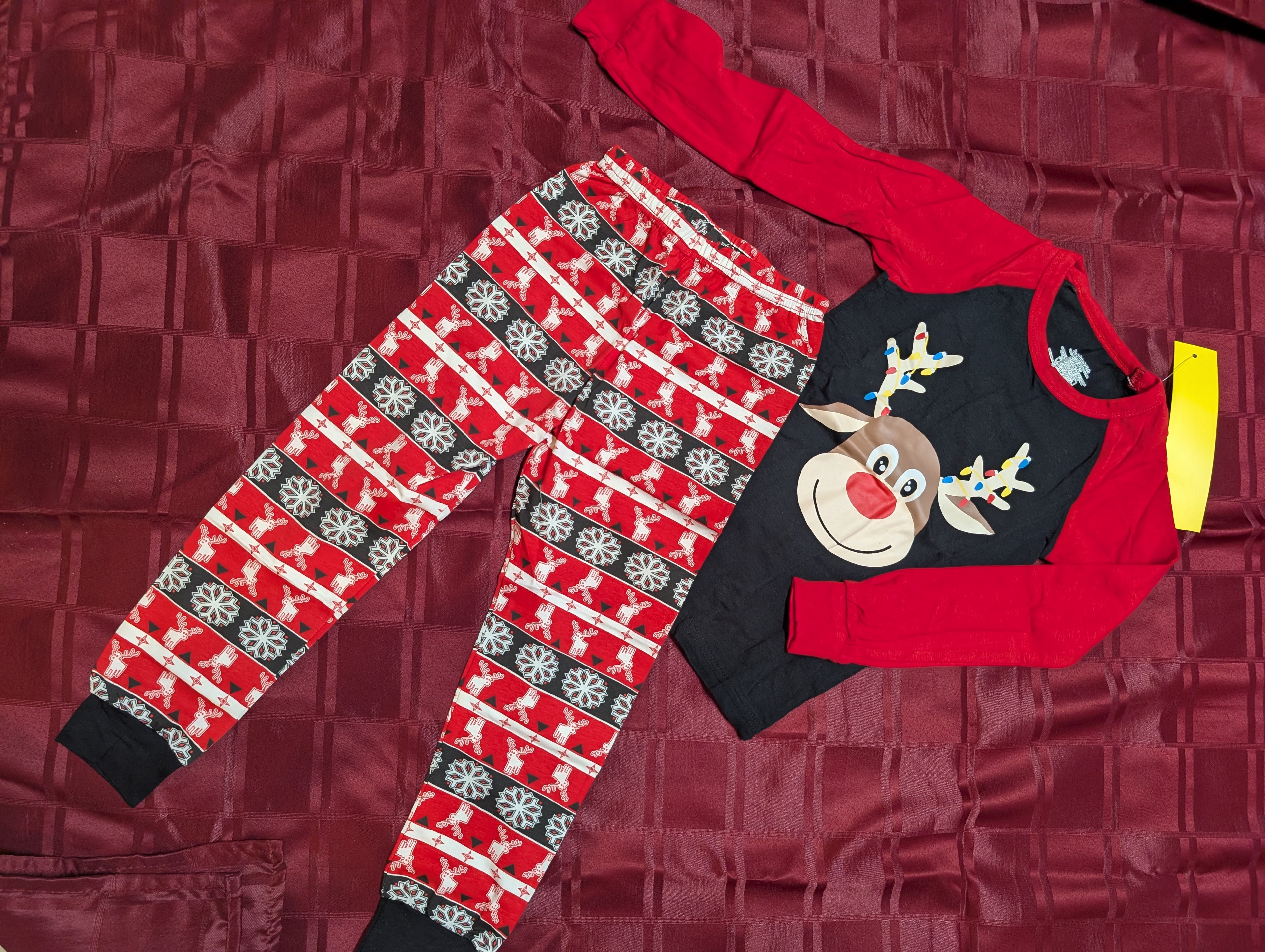 Children's Christmas-themed pajama set with reindeer pattern on a red textured background