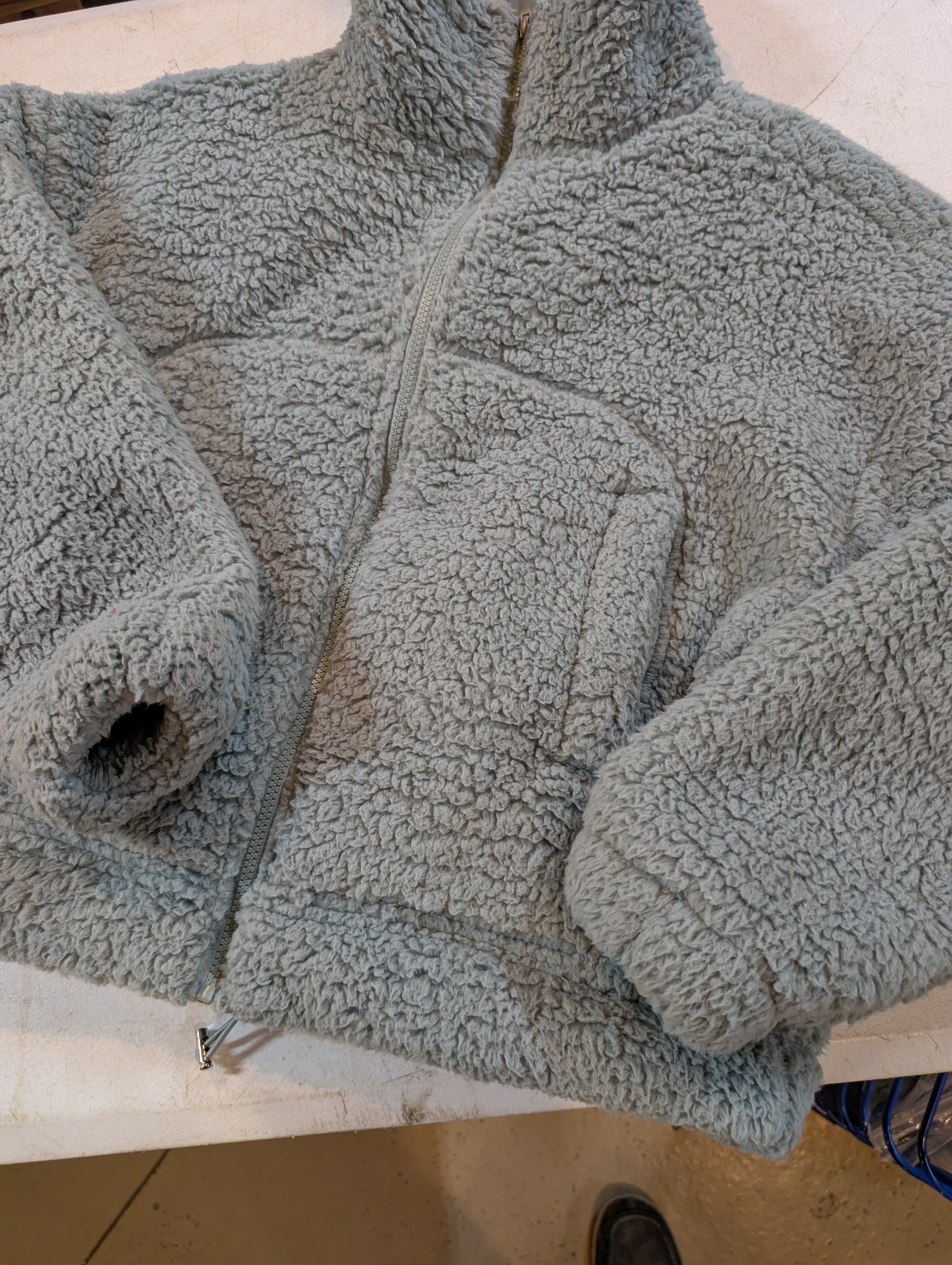 Close-up of a textured gray jacket on a wooden surface