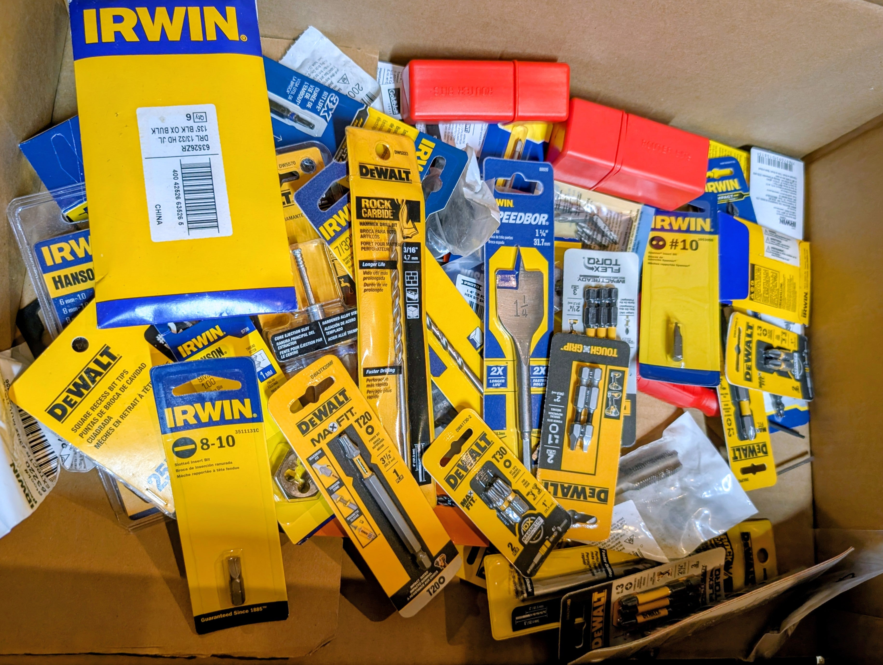 Box of assorted tools with prominent brand labels including Irwin and Dewalt.